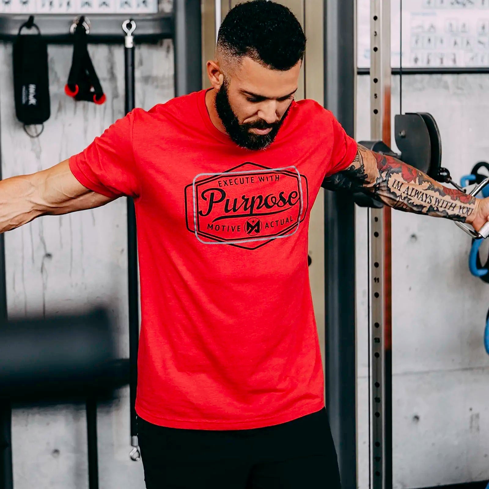 Male wearing red Motive Actual tee Purpose.