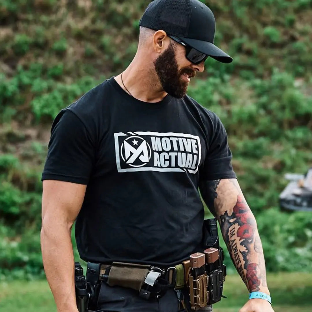 Man wearing black Motive Actual Origins tshirt