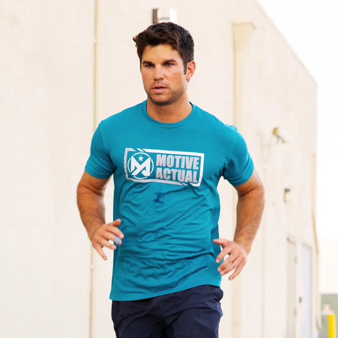 Man wearing teal Motive Actual Origins tshirt
